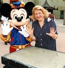 After signing her name next to her hand-prints for Disney's 'Walk of Fame', Barbara Taylor Bradford and Mickey Mouse give a show of hands