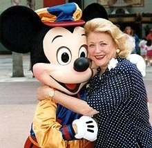 Barbara Taylor Bradford receives a hug from Mickey Mouse following her handprint ceremony at Disney's MGM Studios in Florida. The impression of her handprints remain on permanent display.