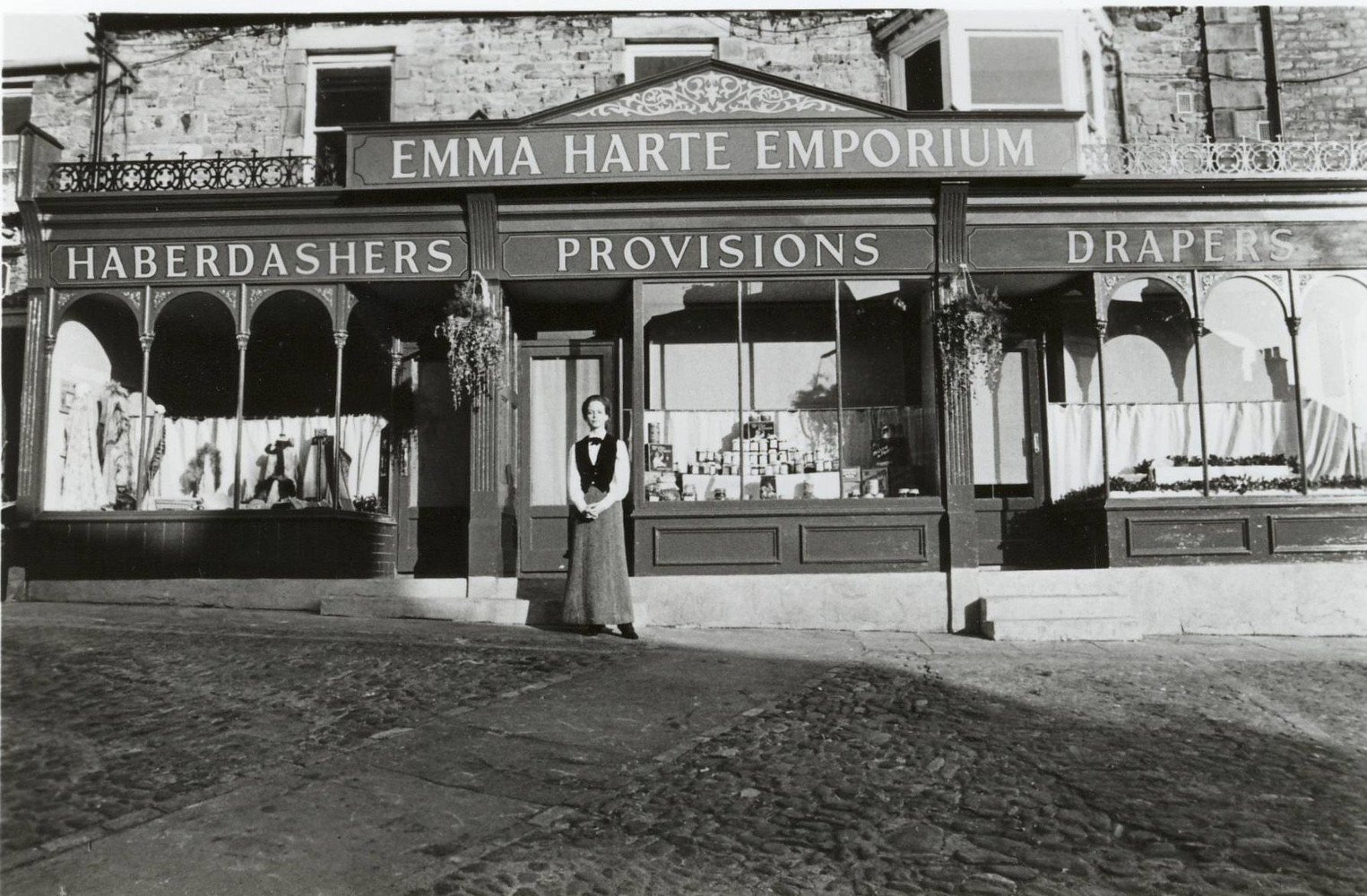 An older Emma Harte (Deborah Kerr) stares at the photo of her younger self (Jenny Seagrove) in front of her first store, Emma Harte's Emporium - from the miniseries of A Woman Of Substance. — with Deborah Kerr and Jenny Seagrove.