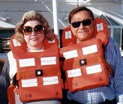 Barbara Taylor Bradford & Bob Bradford in life preservers on a sea cruise