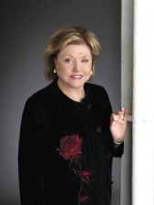 Barbara Taylor Bradford wearing a red rose velvet jacket